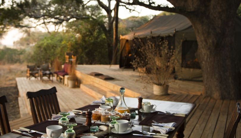 Side-by-side comparison of a luxury private tented suite and a budget safari camp in Tanzania — showing the range of lodge Tanzania safari options available