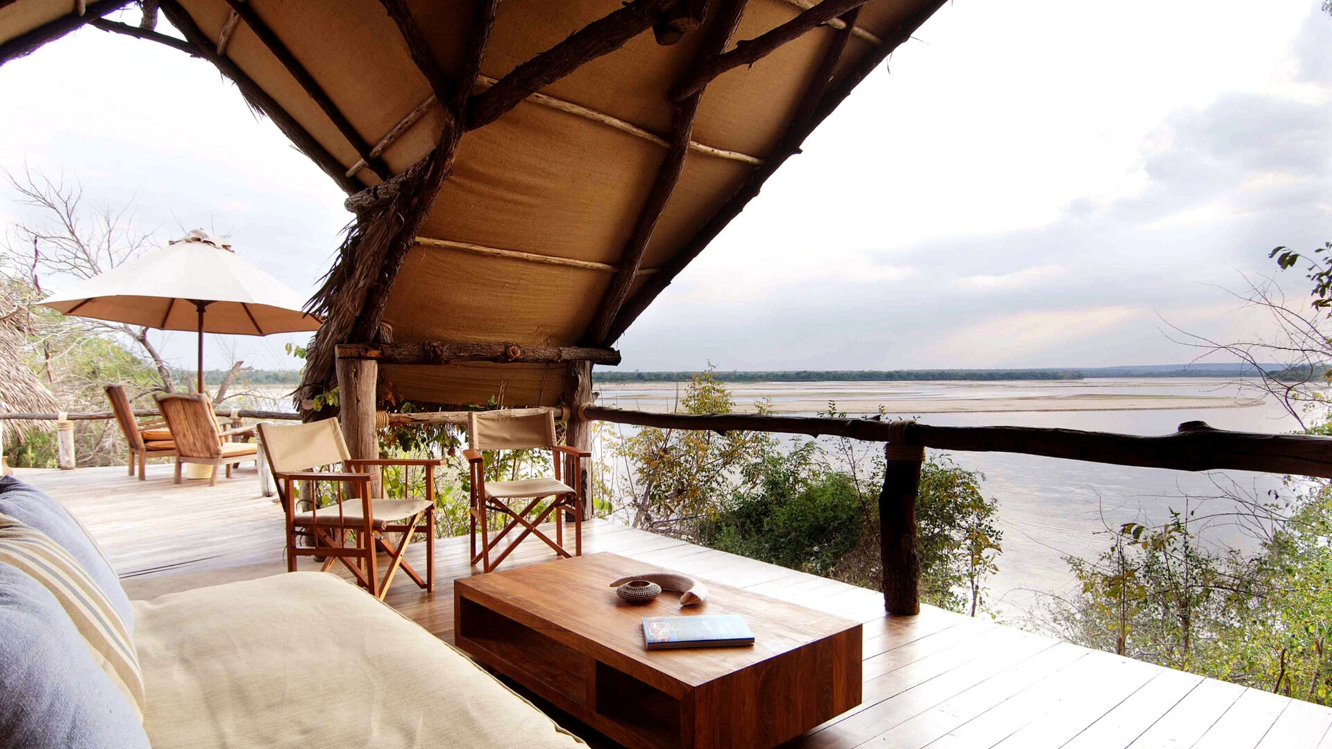 Intimate luxury camp on the Great Ruaha River in Tanzania's southern circuit with elephants visible from the main deck — the character of southern circuit safari accommodation