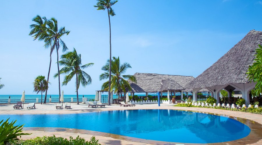 Pristine Zanzibar beach at low tide with a luxury beach villa and turquoise Indian Ocean water — the restorative beach conclusion to a Tanzania safari and Zanzibar combination